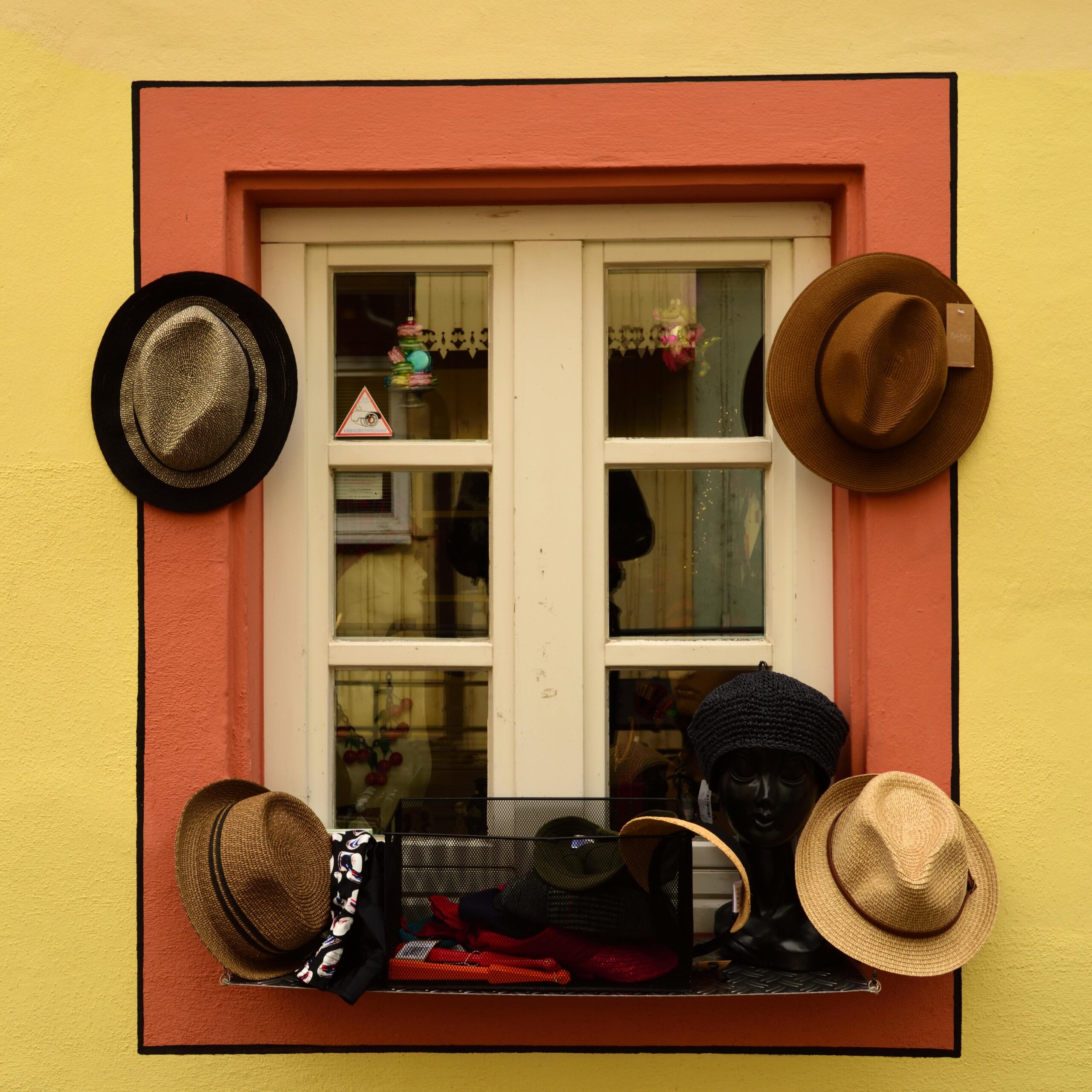 A colorful window display of various hats in Freiburg im Breisgau.