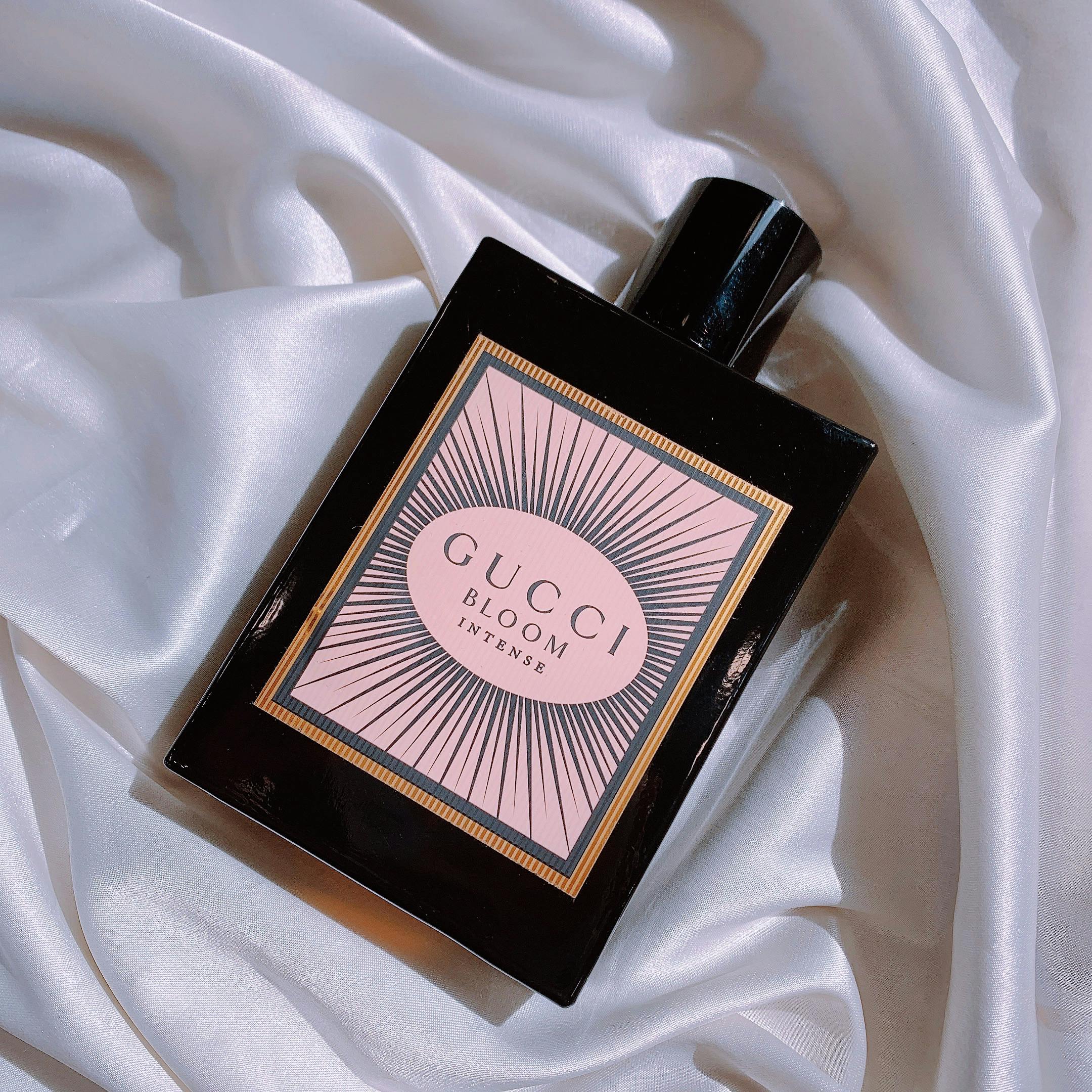 A luxurious perfume bottle displayed elegantly on a smooth white silk fabric, emphasizing opulence.
