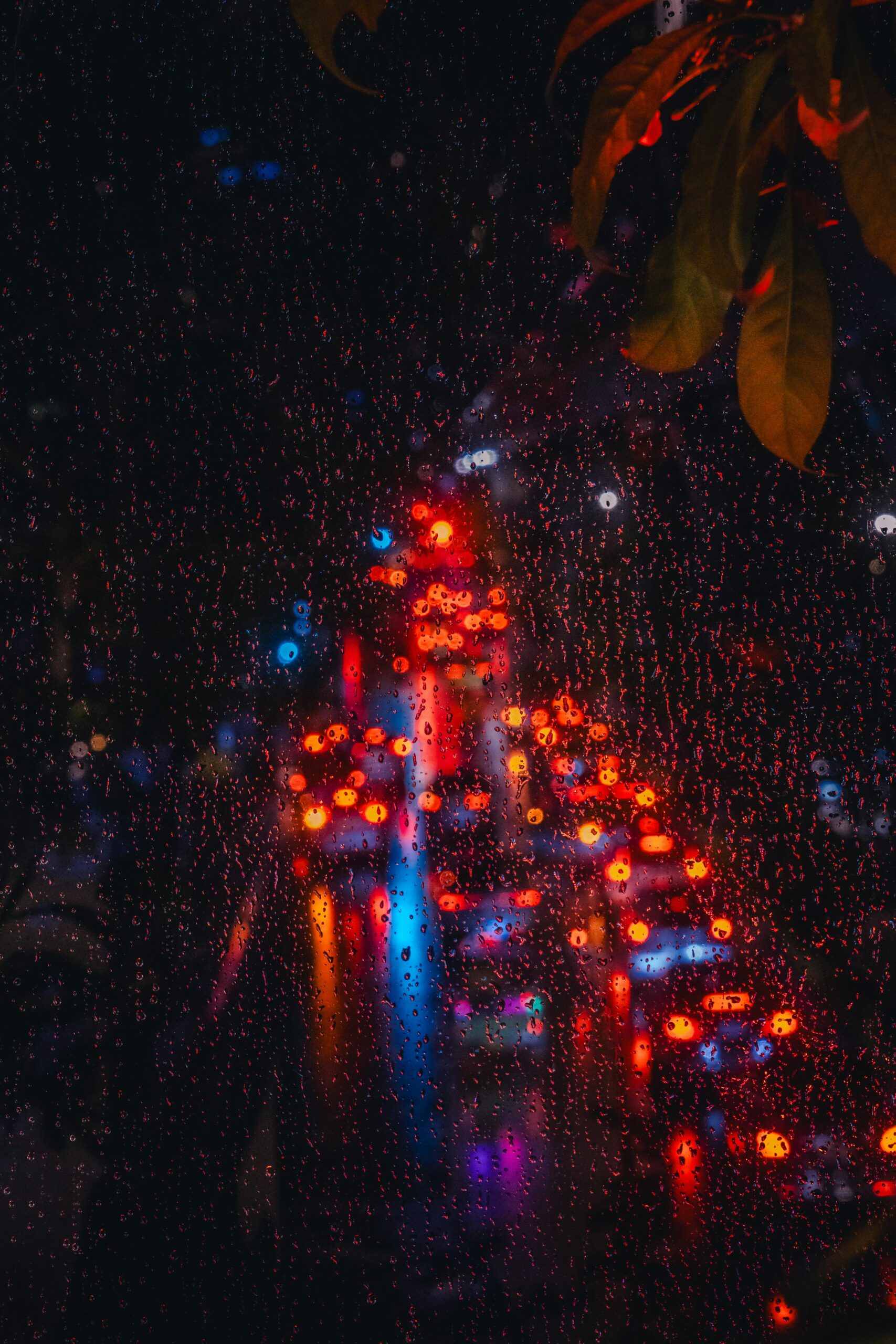 Raindrops on a window with blurred night city lights of Bangkok, capturing the vibrant nightlife.