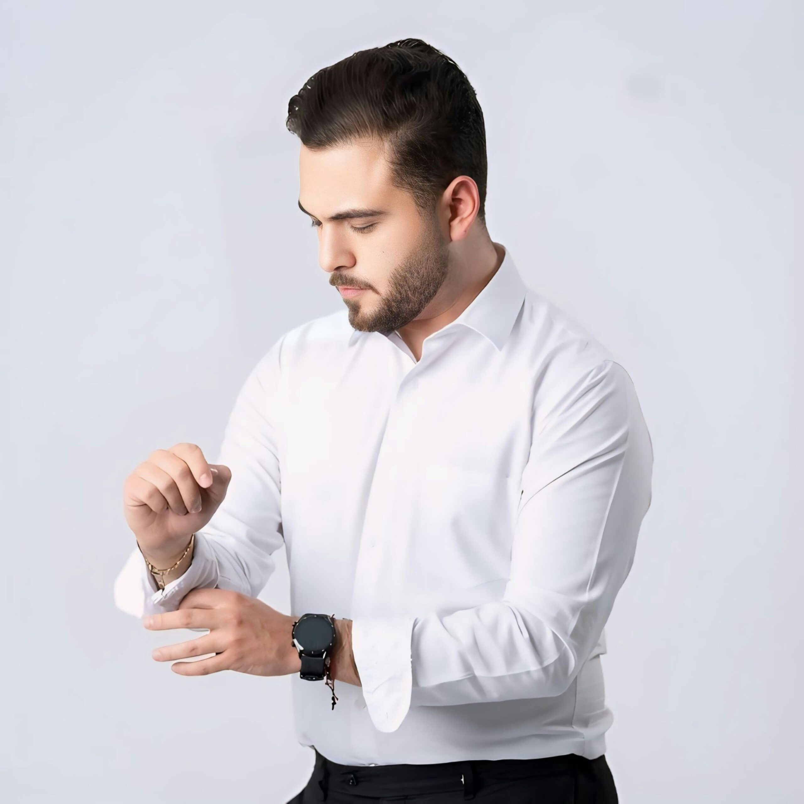 Man in white shirt adjusting sleeve, showcasing elegance and style.