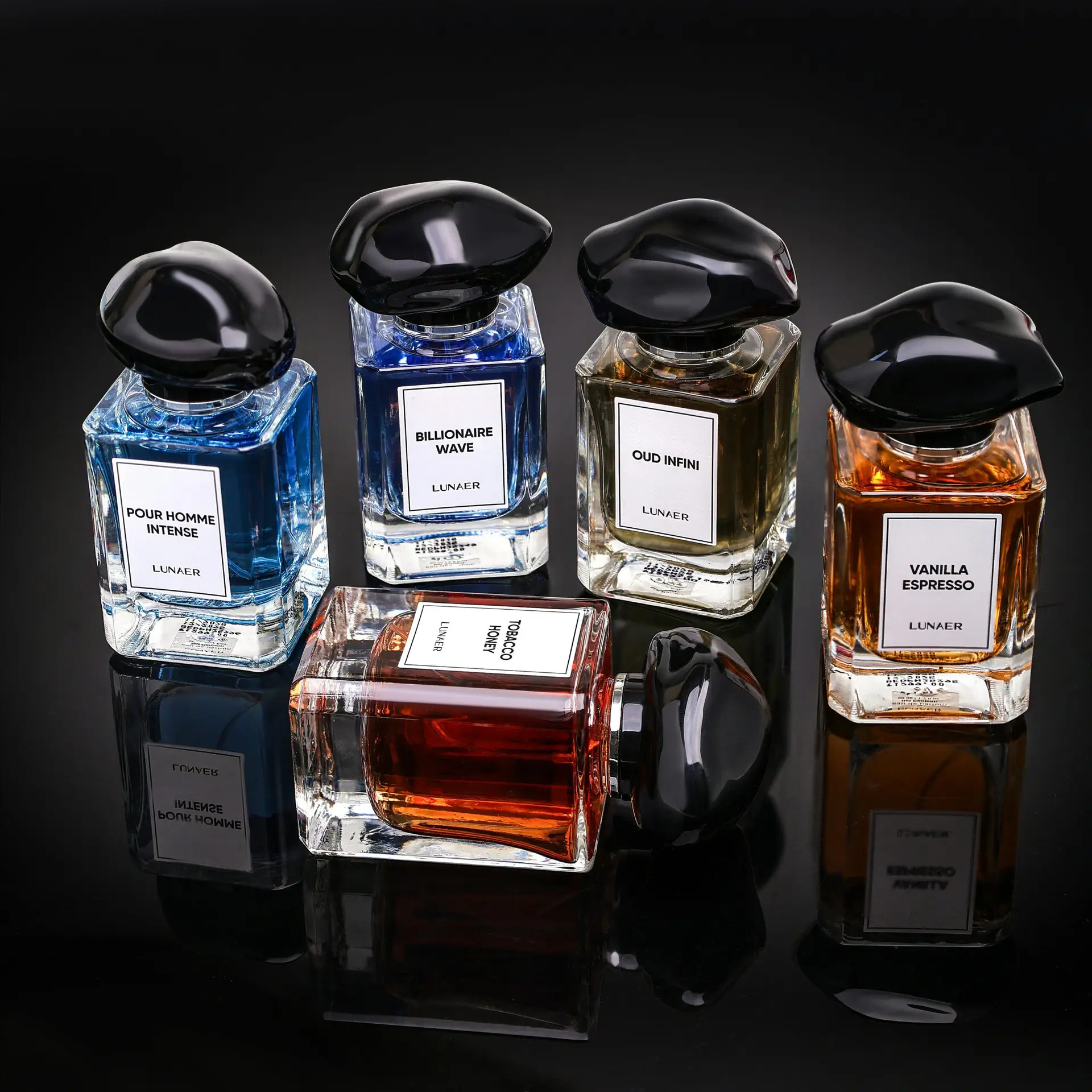 A collection of luxury perfume bottles showcasing premium fragrances on a reflective black surface.